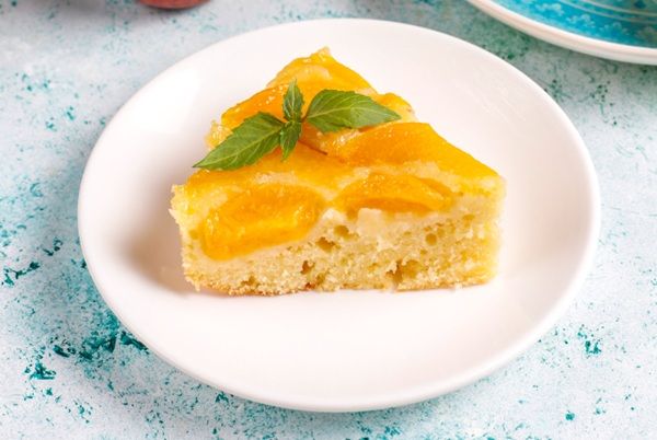 Pastel de durazno presentado en plato blanco