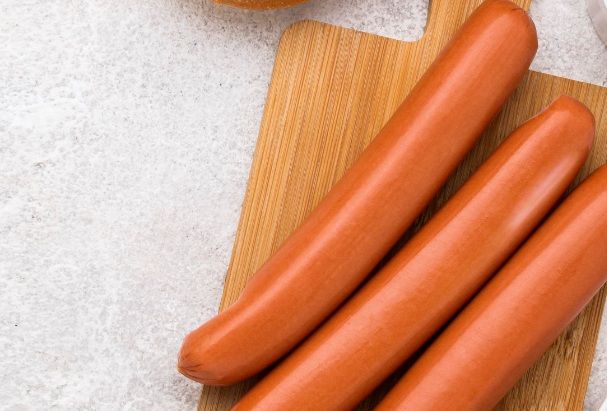 Salchichas sobre tabla de madera listas para preparar los corn dogs