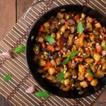 Caponata sicialiana italiana presentada en sartén grande sobre madera