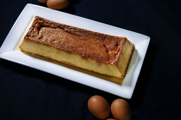 Pan de Calatrava de la abuela presentado en bandeja blanca rectangular con huevos al lado