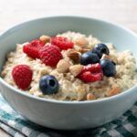 Porridge de avena encima de mantel cuadrado y cuchara de madera