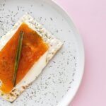 Salmón marinado presentado en plato y encima de cracker