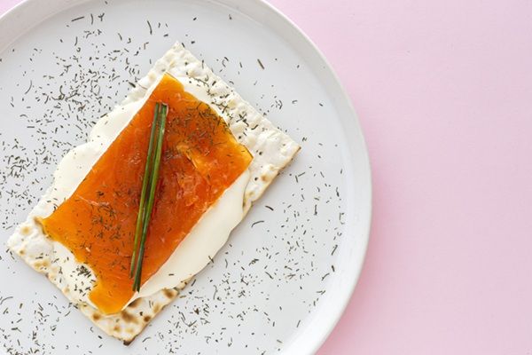 Salmón marinado presentado en plato y encima de cracker