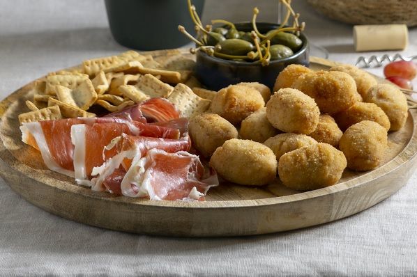 Croquetas de jamón ibérico caseras junto a aceitunas y picos