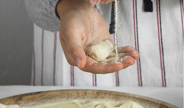 Chef haciendo croquetas con la masa y cubriéndolas de pan rallado