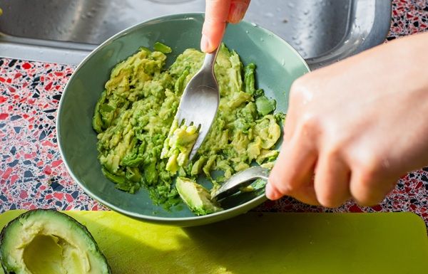 Chef machacando el guacamole en un bol