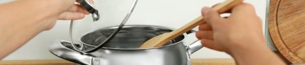 Chef removiendo el cazo de la bechamel con una pala de madera
