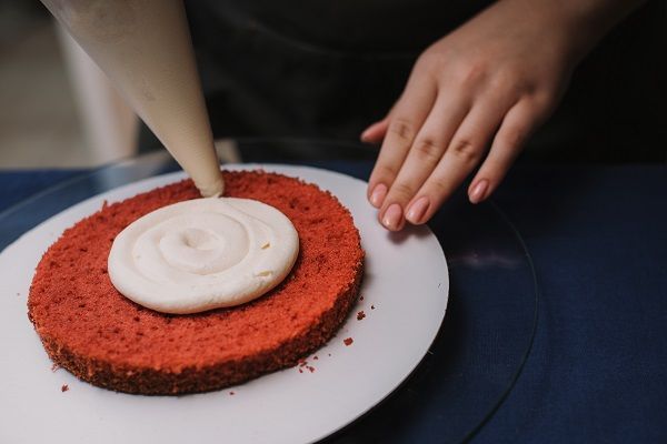 Echar el queso por encima de la tarta red velvet