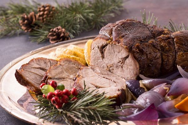 Redondo de ternera asado presentado en bandeja con fondo navideño