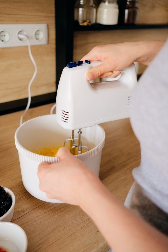 Authentic woman using a handheld mixer