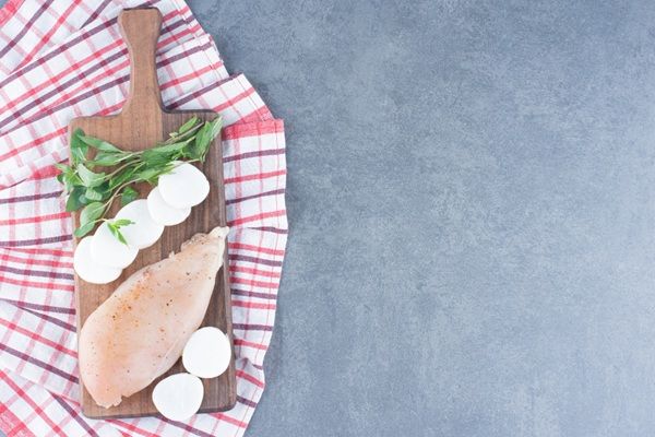 Pechuga de pollo fresca sobre tabla de madera