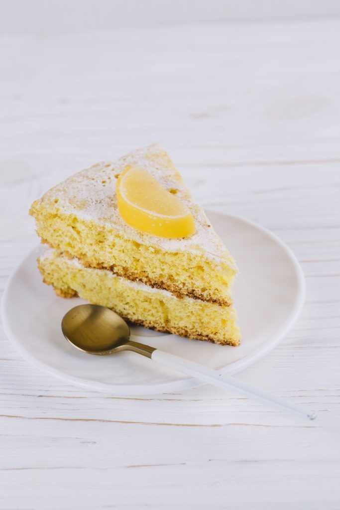primer-plano-rebanada-decorada-torta-limon-placa-blanca-cuchara