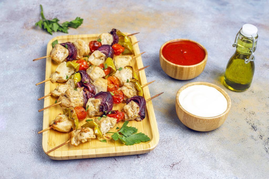 Chicken shish kebab with vegetables,ketchup,mayonnaise,top view