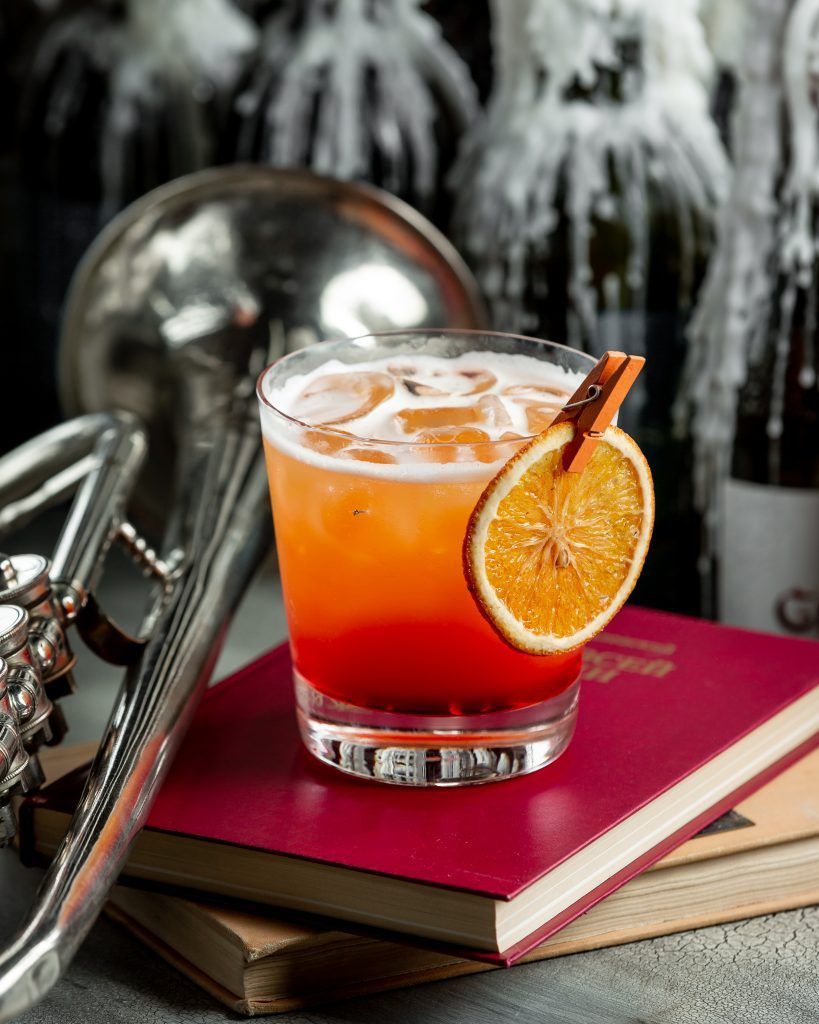 vidrio-rojo-amarillo-anaranjado-jugo-espuma-libro