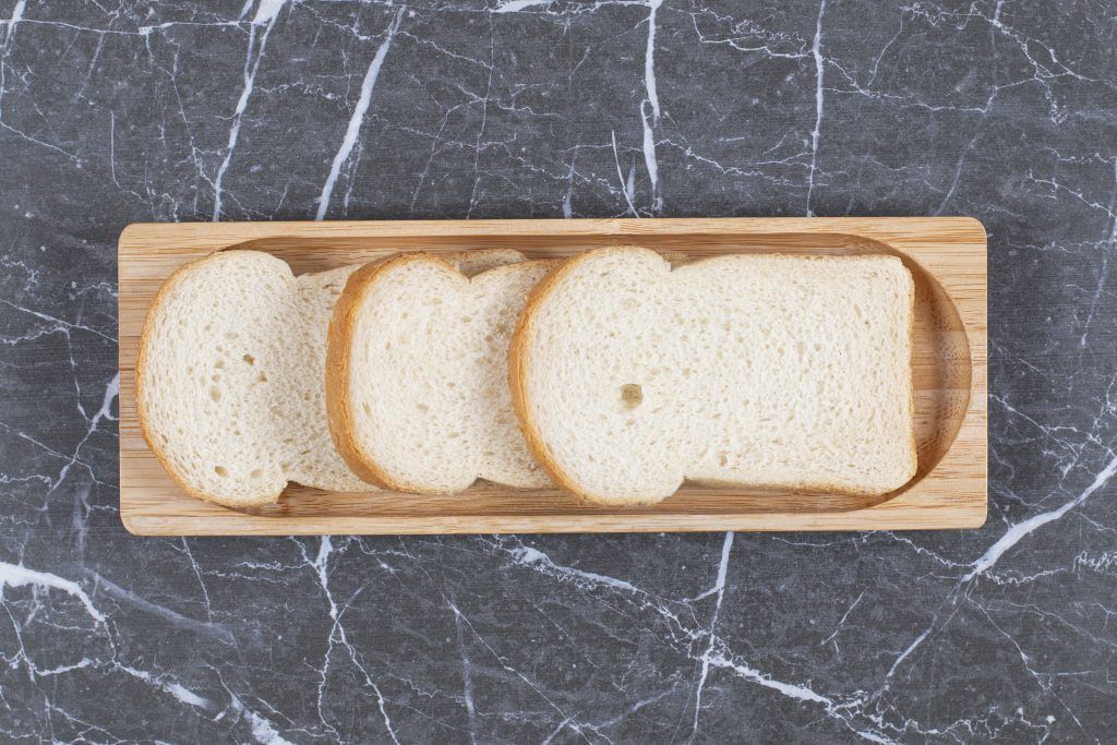 Board with tasty toasted bread, on the marble background