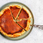 Tarta de queso de La Viña de San Sebastián presentada en plato junto a cuchara de servir