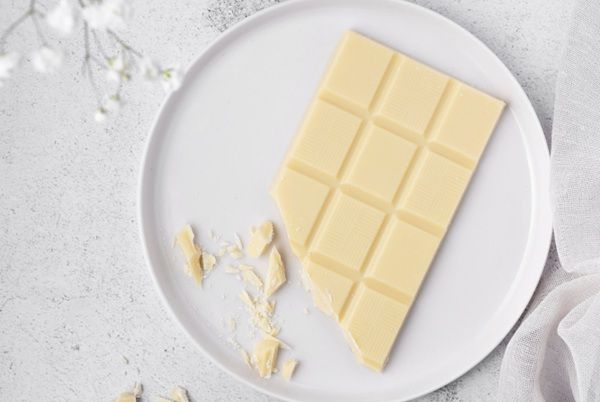 Chocolate blanco sobre plato con un trozo partido
