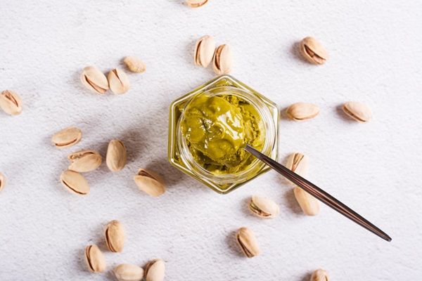 Rica nutella de pistacho con ingredientes alrededor vista desde arriba