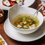 Sopa de verduras servida con hierbas