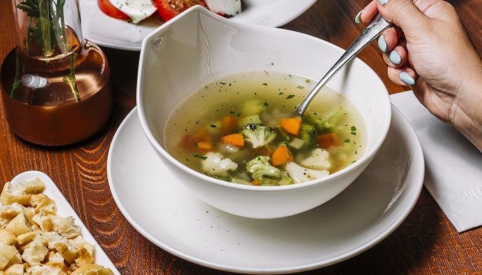 Sopa de verduras servida con hierbas