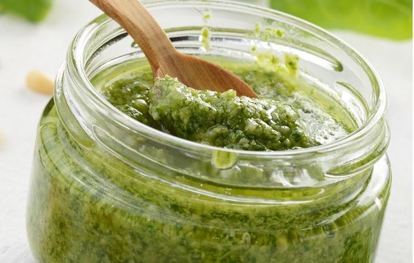 Mojo verde canario guardado en tarro de cristal junto a cuchara de madera