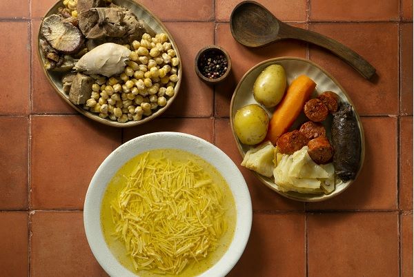 Cocido madrileño auténtico tradicional presentado en tres platos diferentes con los fideos, garbanzos, carnes y verduras