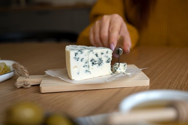 Chef cortando queso azul