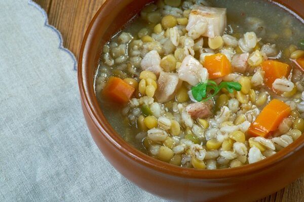 Hernesupp suitsulihaga o sopa de guisantes con carne ahumada presentada en cuenco marrón sobre mesa de madera