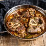 Osobuco de ternera tradicional con gremolata presentado en olla y paño debajo
