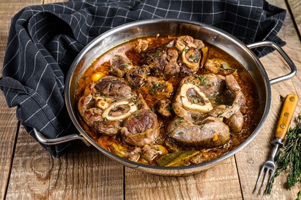 Osobuco de ternera tradicional con gremolata presentado en olla y paño debajo