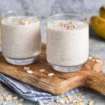 Batidos de plátano y avena sobre tabla de madera e ingredientes alrededor