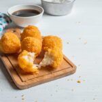 Bolitas de queso sobre tabla de madera