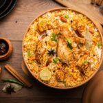 Imagen de biryani de pollo con salsas al lado
