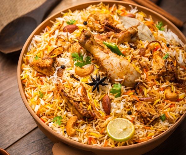 Imagen de biryani de pollo vista lateral con cuchara de madera